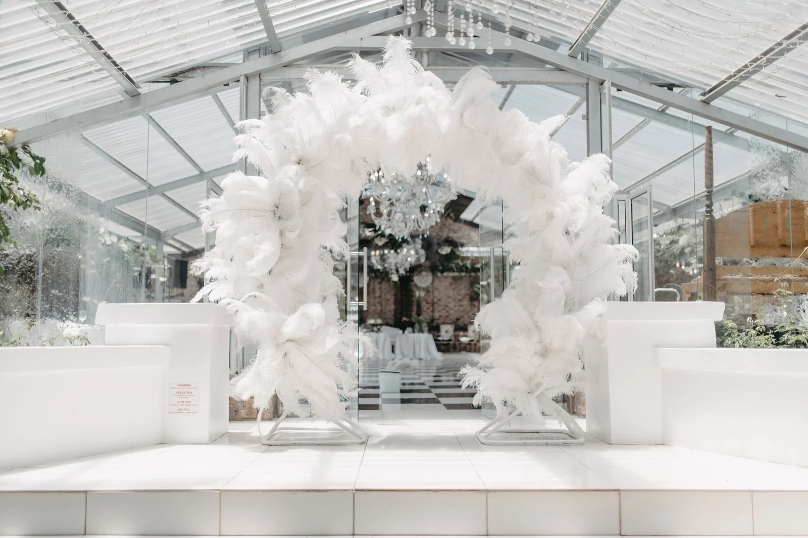 White ostrich-feather arch at the entrance to the De Opstal function venue